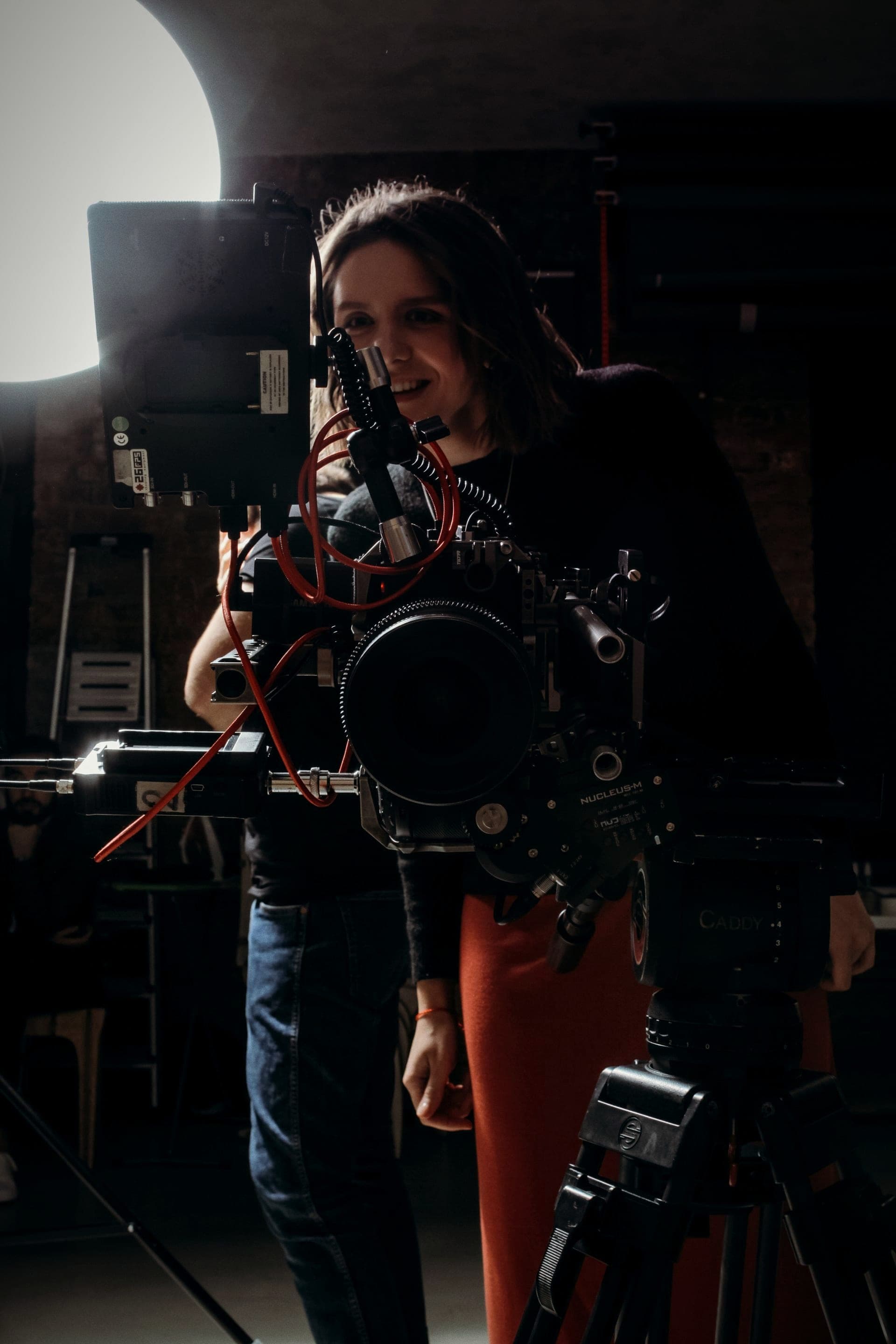 A camera operator frames a shot through a cinema camera.