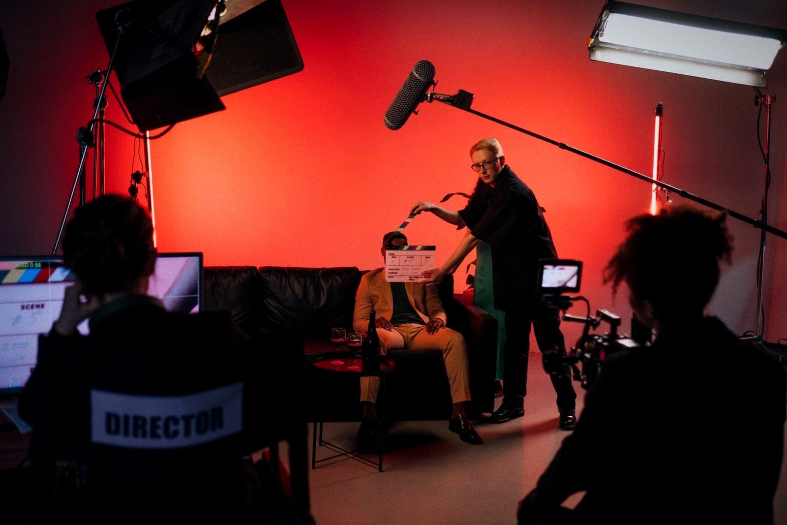 A director and crew at work on a lit interior set.